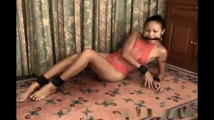 Schlanke Asiatin in roter Lingerie, gefesselt und geknebelt