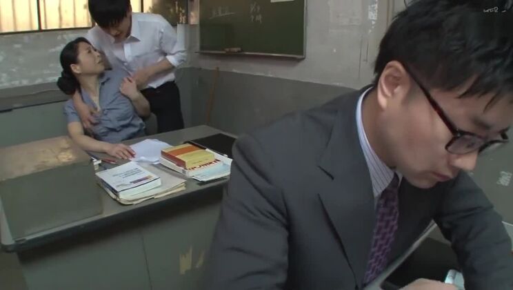 Reife Lehrerin in Strumpfhosen befriedigt sich im Büro mit den Fingern.